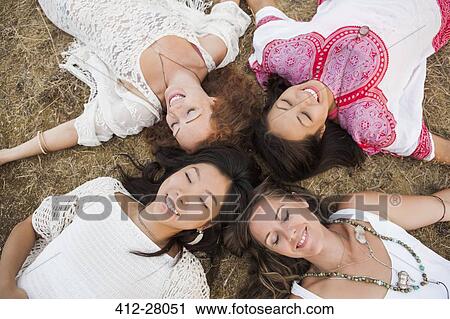 Overhead view of smiling boho women laying in circle with eyes closed View Large Photo Image Stock Image - Overhead view of smiling boho women laying in circle with eyes closed. Fotosearch