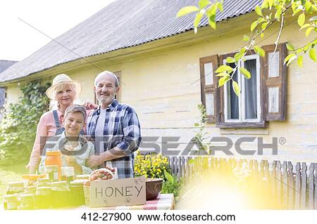 Portrait proud grandparents and grandson selling honey View Large Photo Image Stock Image - Portrait proud grandparents and grandson selling honey. Fotosearch