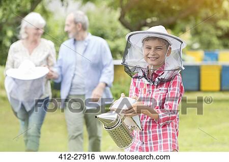 Portrait smiling boy in beekeeper hat holding smoker View Large Photo Image Stock Photograph - Portrait smiling boy in beekeeper hat holding smoker. Fotosearch