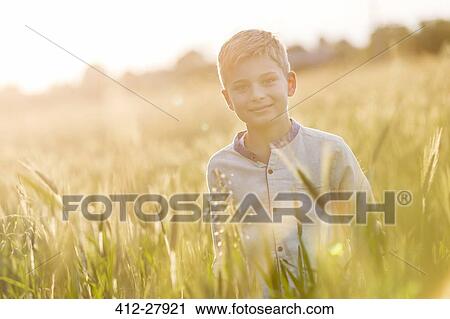 Portrait smiling boy in sunny rural wheat field View Large Photo Image Stock Image - Portrait smiling boy in sunny rural wheat field. Fotosearch