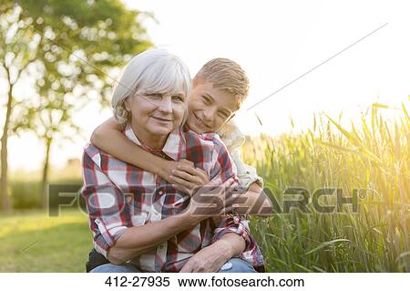 Portrait smiling grandmother and grandson hugging near sunny rural wheat field View Large Photo Image Stock Photography - Portrait smiling grandmother and grandson hugging near sunny rural wheat field. Fotosearch