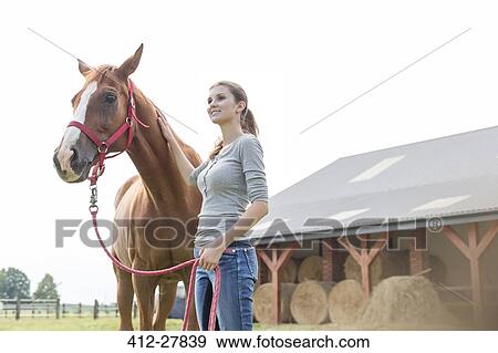 Smiling woman with horse outside rural barn View Large Photo Image Stock Photo - Smiling woman with horse outside rural barn. Fotosearch