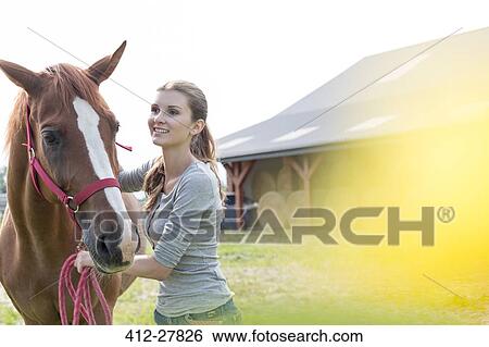 Smiling woman with horse outside rural barn View Large Photo Image Stock Photograph - Smiling woman with horse outside rural barn. Fotosearch