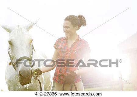 Stock Photograph - Smiling woman with horse. Fotosearch