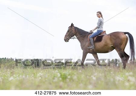 Woman horseback riding in rural field View Large Photo Image Stock Photography - Woman horseback riding in rural field. Fotosearch