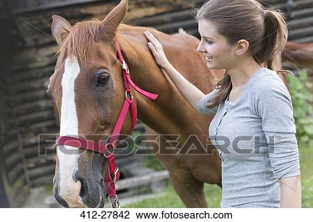 Woman petting horse View Large Photo Image Stock Image - Woman petting horse. Fotosearch