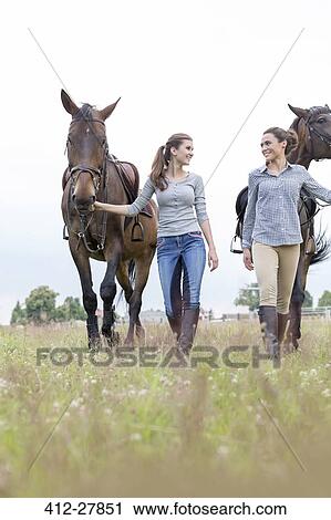Women walking horses in rural field View Large Photo Image Stock Image - Women walking horses in rural field. Fotosearch