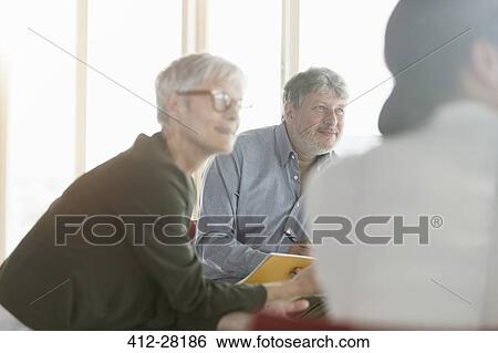 Stock Photograph - Attentive business people listening in meeting. Fotosearch