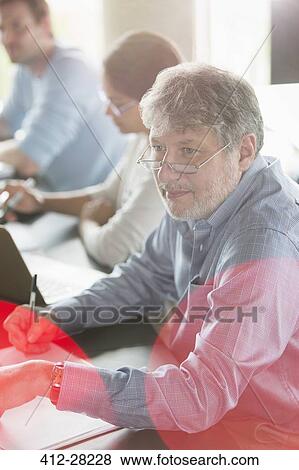 Stock Photo - Businessman taking notes in meeting. Fotosearch