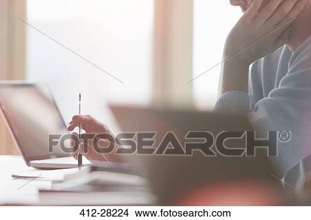 Picture - Businessman working at laptop in classroom. Fotosearch