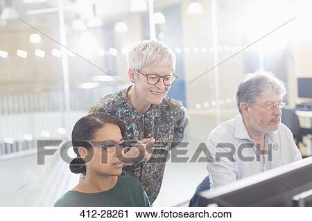 Stock Image - Businesswomen working at computer in office. Fotosearch