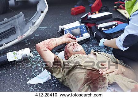 Stock Image - Car accident victim laying in road. Fotosearch