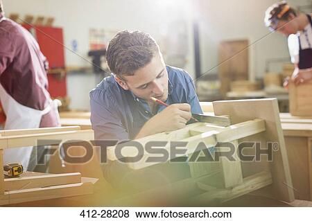 Carpenter measuring and marking wood in workshop View Large Photo Image Stock Photo - Carpenter measuring and marking wood in workshop. Fotosearch