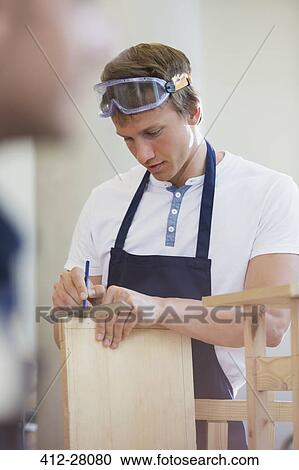Carpenter measuring wood in workshop View Large Photo Image Stock Image - Carpenter measuring wood in workshop. Fotosearch