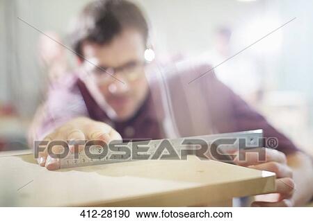 Carpenter measuring wood in workshop View Large Photo Image Stock Image - Carpenter measuring wood in workshop. Fotosearch