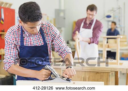 Carpenter using plane tool in workshop View Large Photo Image Stock Photograph - Carpenter using plane tool in workshop. Fotosearch
