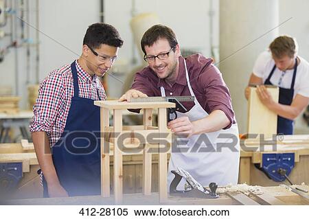 Stock Photography - Carpenters measuring wood in workshop. Fotosearch