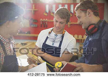 Stock Photography - Carpenters measuring wood in workshop. Fotosearch