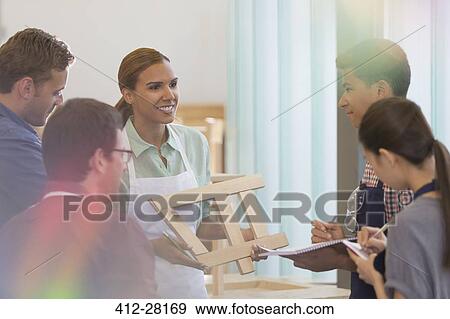 Stock Photo - Carpentry students taking notes in workshop. Fotosearch