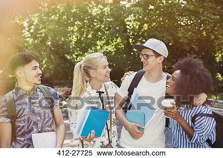 Stock Photography - College students with books and coffee walking in park. Fotosearch