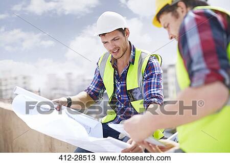 Construction worker and engineer reviewing blueprints at construction site View Large Photo Image Stock Image - Construction worker and engineer reviewing blueprints at construction site. Fotosearch
