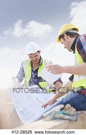 Stock Photograph - Construction worker and engineer discussing blueprints. Fotosearch