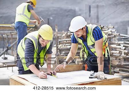 Construction worker and engineer revising blueprints at construction site View Large Photo Image Stock Photography - Construction worker and engineer revising blueprints at construction site. Fotosearch