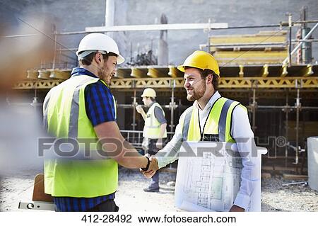 Construction worker and engineer with blueprints handshaking at construction site View Large Photo Image Stock Image - Construction worker and engineer with blueprints handshaking at construction site. Fotosearch