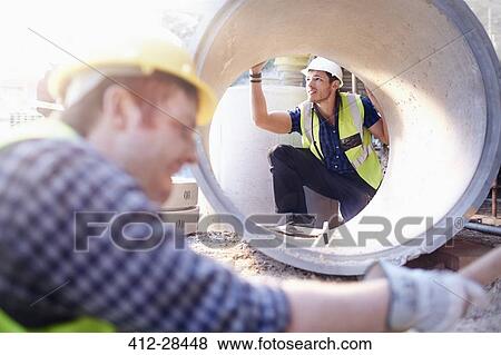 Construction worker examining concrete pipe View Large Photo Image Stock Photo - Construction worker examining concrete pipe. Fotosearch