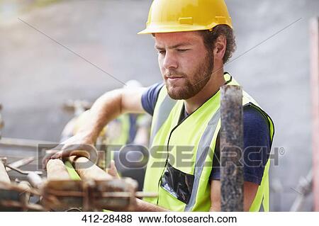 Construction worker lifting rebar View Large Photo Image Stock Photo - Construction worker lifting rebar. Fotosearch