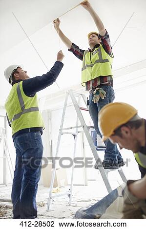 Construction worker on ladder at construction site View Large Photo Image Stock Image - Construction worker on ladder at construction site. Fotosearch