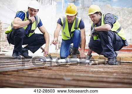 Construction workers and engineer reviewing blueprints at construction site View Large Photo Image Stock Image - Construction workers and engineer reviewing blueprints at construction site. Fotosearch