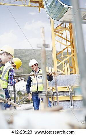 Construction workers assembling structure at highrise construction site View Large Photo Image Stock Image - Construction workers assembling structure at highrise construction site. Fotosearch