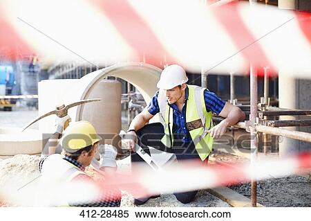 Stock Photography - Construction workers talking at construction site. Fotosearch