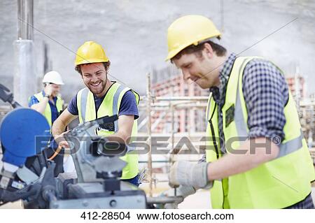Construction workers using equipment at construction site View Large Photo Image Picture - Construction workers using equipment at construction site. Fotosearch