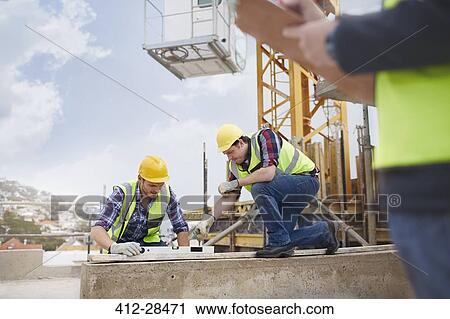 Construction workers using level tool at construction site View Large Photo Image Stock Image - Construction workers using level tool at construction site. Fotosearch