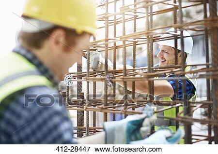 Constructor workers assembling rebar structure at construction site View Large Photo Image Stock Photo - Constructor workers assembling rebar structure at construction site. Fotosearch