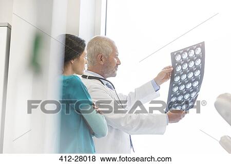 Stock Photo - Doctor and nurse reviewing x-rays in doctor’s office. Fotosearch