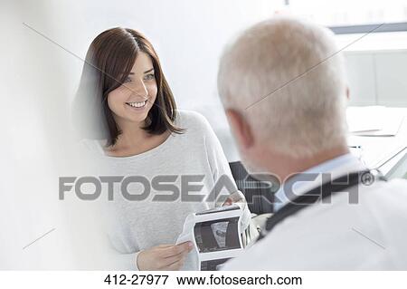 Doctor and patient looking at ultrasound x-rays in doctor’s office View Large Photo Image Stock Photo - Doctor and patient looking at ultrasound x-rays in doctor’s office. Fotosearch