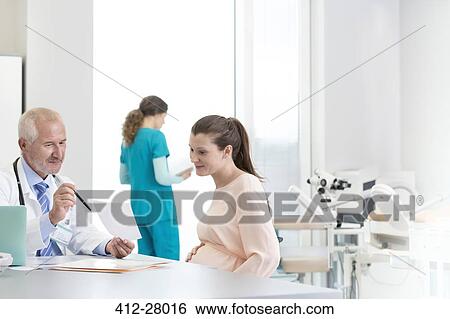 Doctor and pregnant patient discussing prescription in clinic View Large Photo Image Stock Photograph - Doctor and pregnant patient discussing prescription in clinic. Fotosearch