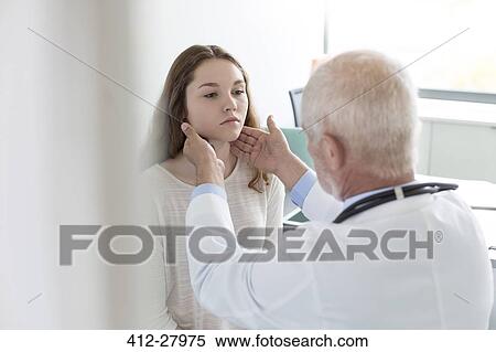 Doctor checking teenage patient’s glands in examination room View Large Photo Image Stock Photography - Doctor checking teenage patient’s glands in examination room. Fotosearch