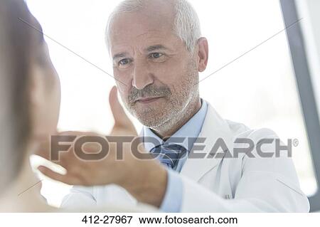 Stock Photo - Doctor examining patient’s glands in checkup. Fotosearch