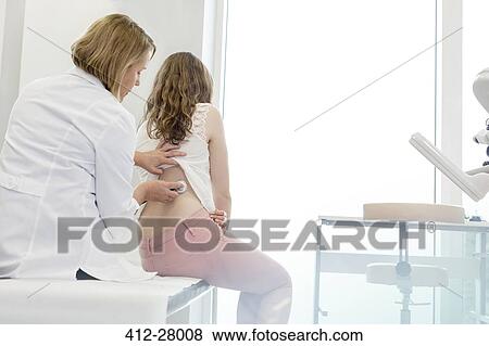 Doctor using stethoscope on teenage patient’s back in examination room View Large Photo Image Stock Photo - Doctor using stethoscope on teenage patient’s back in examination room. Fotosearch