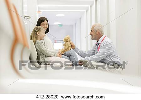 Doctor with teddy bear talking to girl patient in clinic corridor View Large Photo Image Stock Image - Doctor with teddy bear talking to girl patient in clinic corridor. Fotosearch