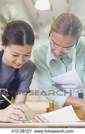 Female carpenters drafting blueprints in workshop View Large Photo Image Stock Photo - Female carpenters drafting blueprints in workshop. Fotosearch