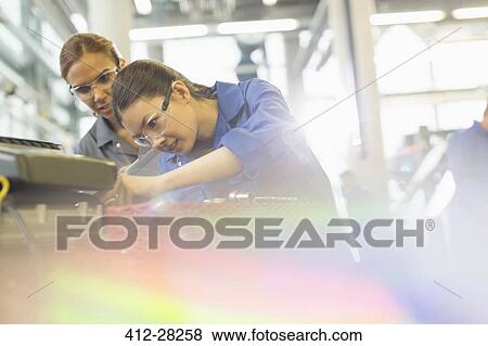 Female mechanics working on engine in auto repair shop View Large Photo Image Stock Photo - Female mechanics working on engine in auto repair shop. Fotosearch