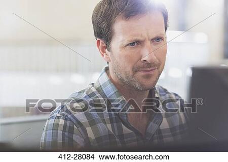 Picture - Focused businessman working at computer. Fotosearch