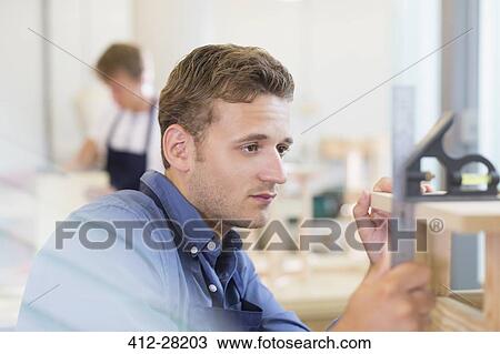 Focused carpenter measuring wood in workshop View Large Photo Image Stock Image - Focused carpenter measuring wood in workshop. Fotosearch