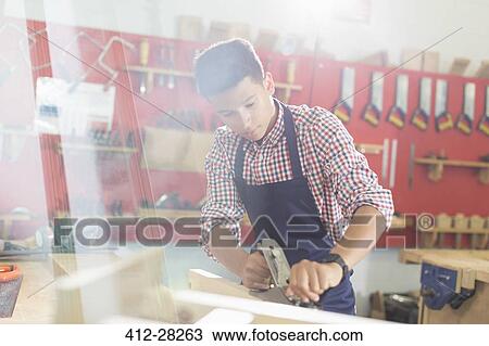 Focused carpenter working in workshop View Large Photo Image Stock Image - Focused carpenter working in workshop. Fotosearch