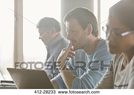 Focused man studying in adult education classroom View Large Photo Image Stock Image - Focused man studying in adult education classroom. Fotosearch